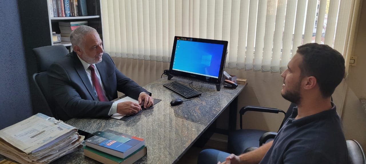 Dr. Vinicius atendendo cliente no escritório